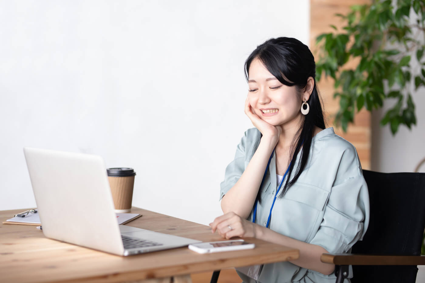 Image of a young woman sitting at a computer, visibly stressed, gripping her jaw as she clenches her teeth.