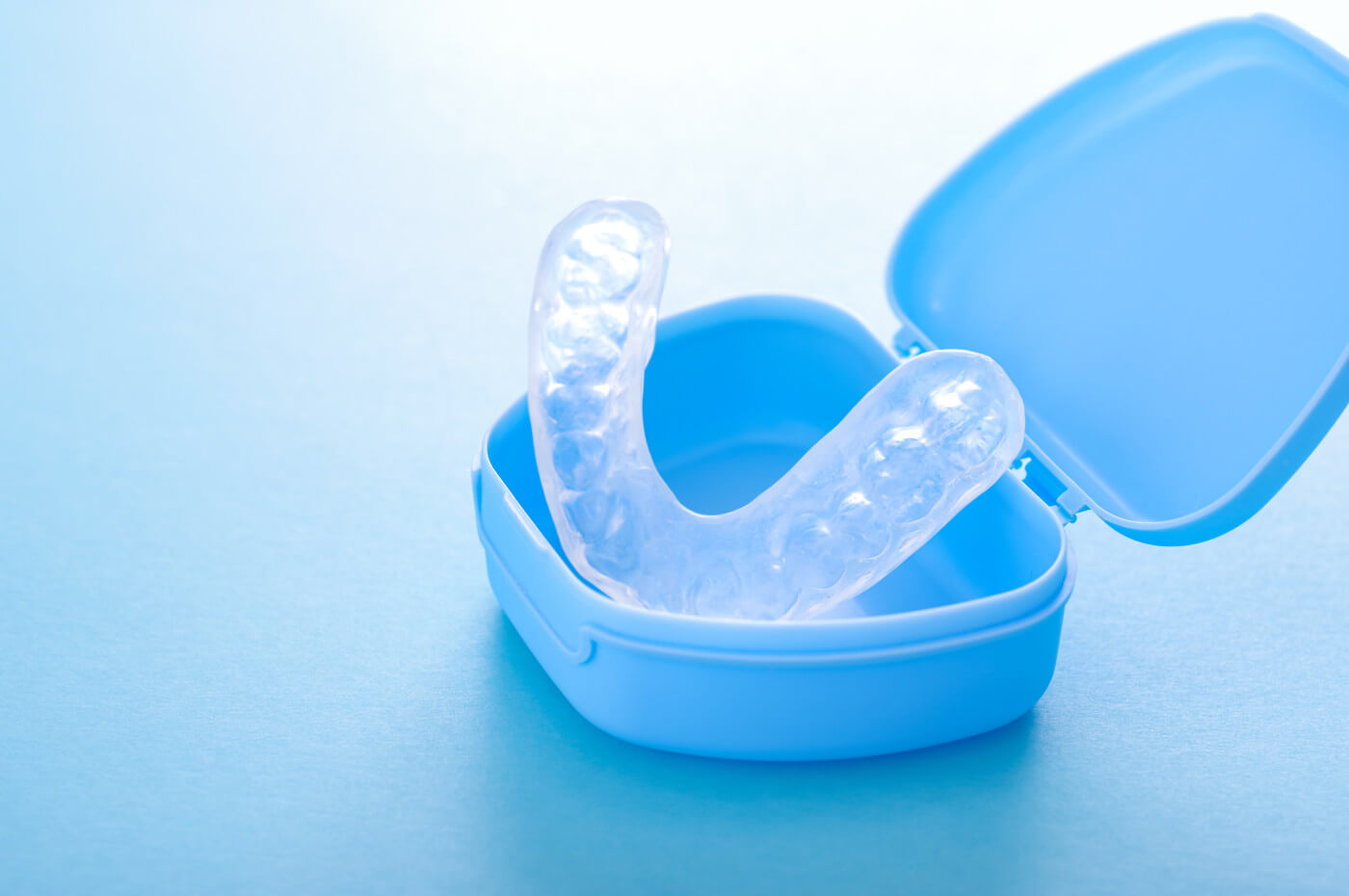 Image of night guard for teeth grinding in a blue case.  