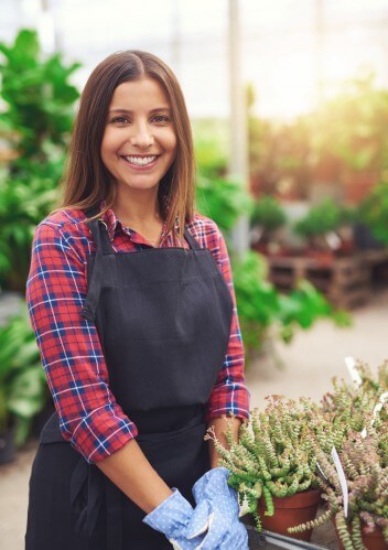 Young woman smiling in her greenhouse
