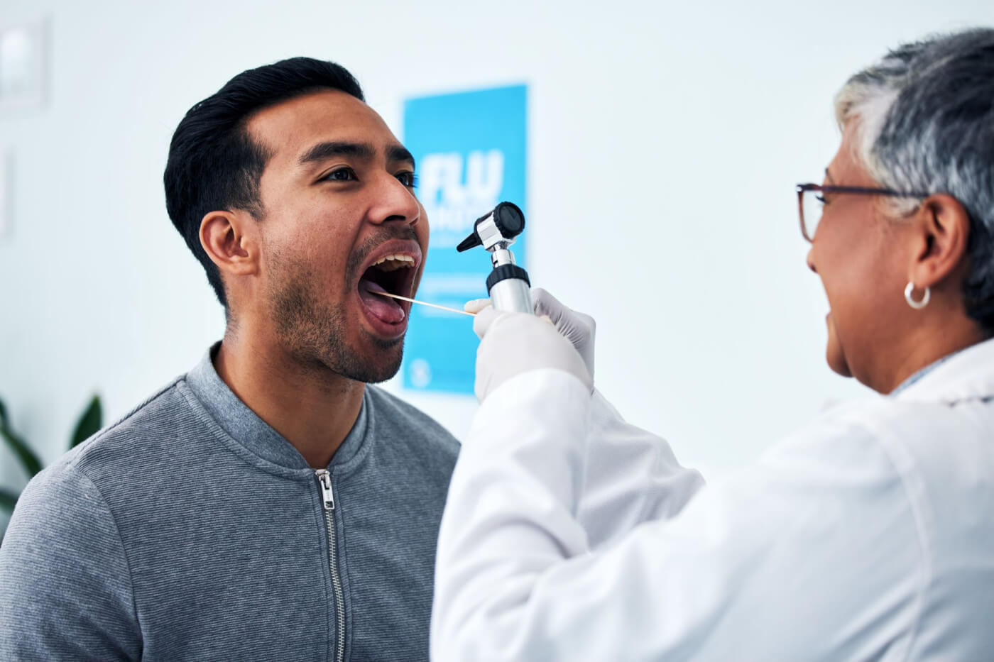 Male patient receiving an oral cancer screening examination by a healthcare professional. 