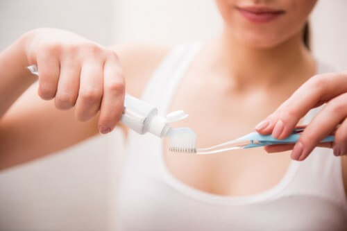 Girl putting toothpaste on a toothbrush